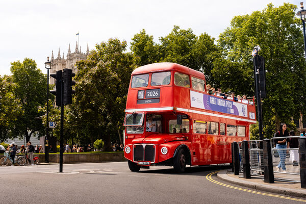 The Great British Pitch India branded double-decker bus passing Westminster